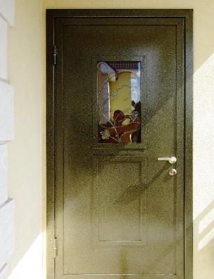 Фото установленной двери с ковкой