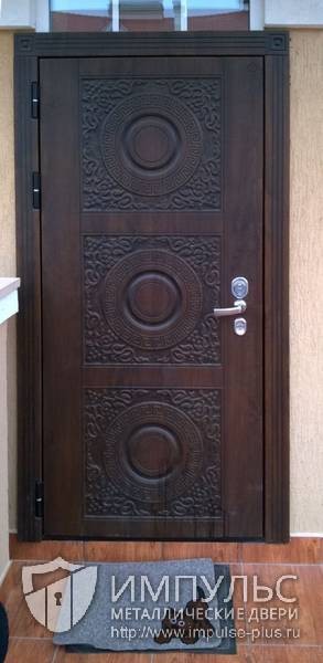 Фото установленной двери с декоративной отделкой